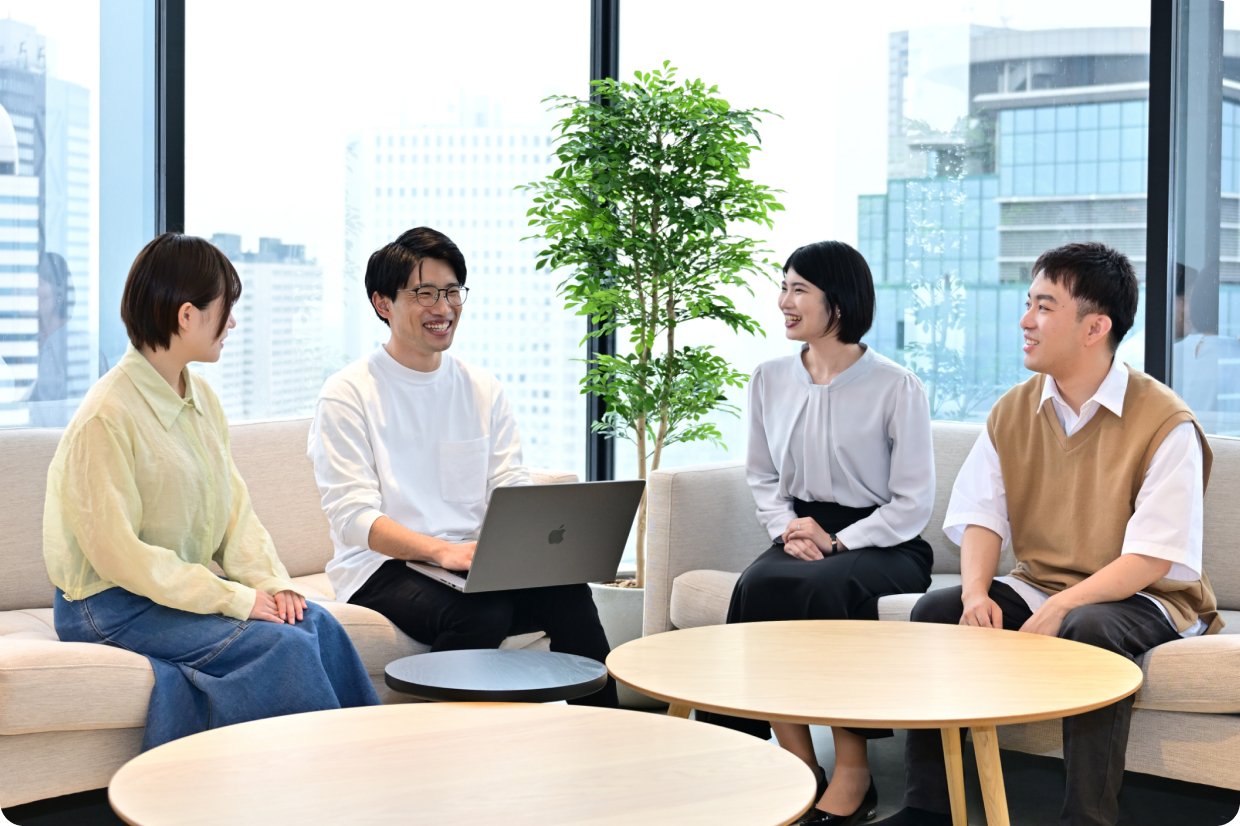 ソファで話し合う4人の社員